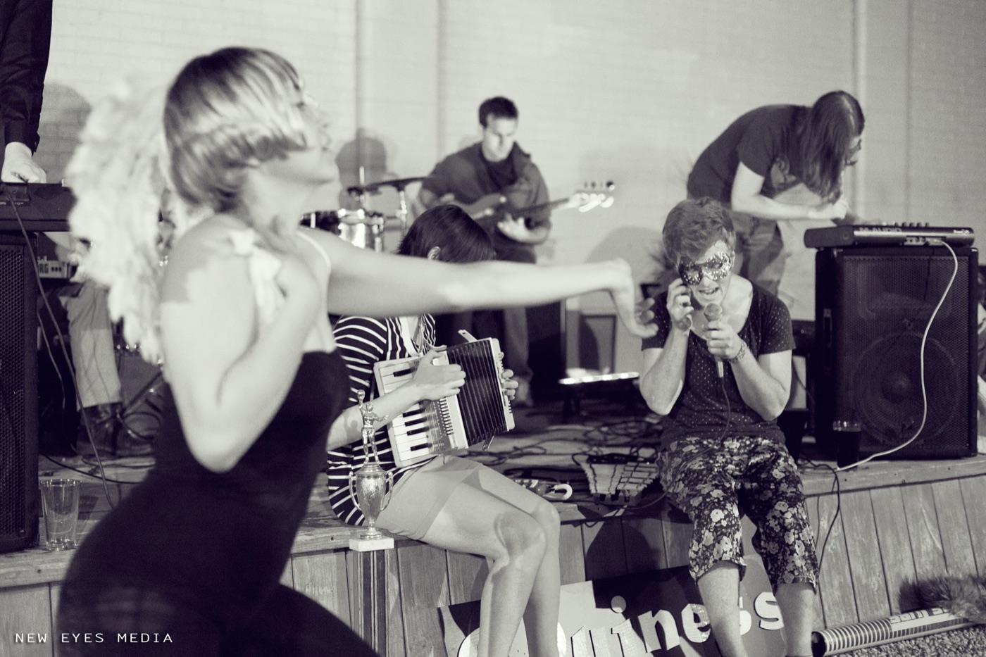 Black and white shot: dancer, masked singer, accordion